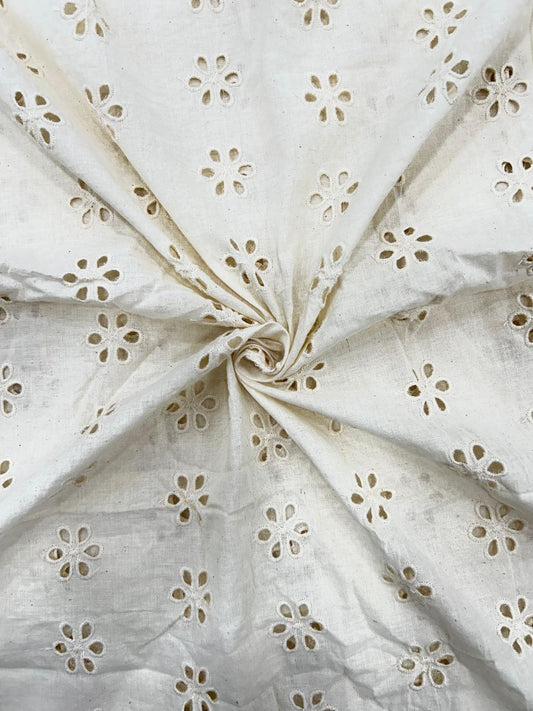 Close-up of soft, 44-inch cotton textile featuring a unique geometric embroidered circle pattern, ideal for stylish blouses and apparel.