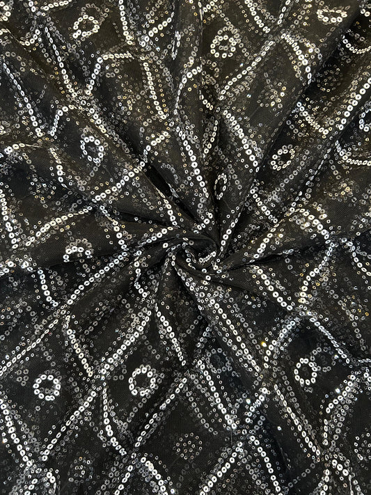 Close-up of shimmering black sequin work on net fabric, featuring elegant diamond and circle patterns, ideal for party wear suits and anarkalis.