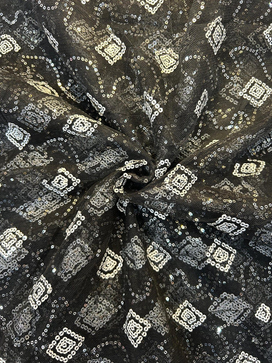 Close-up of dazzling black net textile with intricate white sequin embroidery, ideal for festive sarees, anarkalis, and designer party wear.