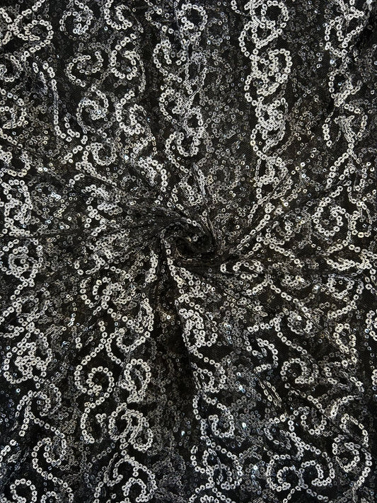 Close-up of luxury black net fabric with all-over white sequin work, great for creating sophisticated party wear suits and high-end apparel.