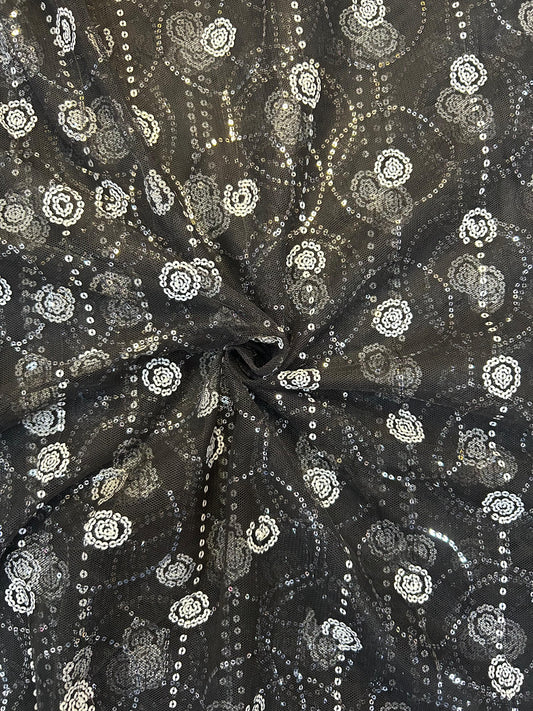 Close-up of dazzling black net textile with all-over shimmering white sequin work, ideal for elegant sarees, anarkalis, and party wear outfits.
