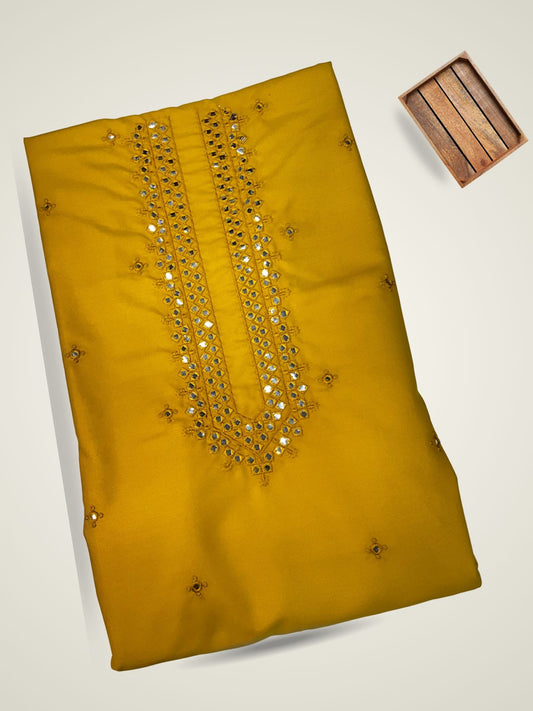"Brighten your wardrobe with this stunning mustard yellow unstitched kurta fabric for men! It features rich, intricate gold embroidery and shimmering mirror work (shisha work) embellishments along the detailed V-neckline. This vibrant premium ethnic fabric is ideal for tailoring a stylish men's kurta pajama set perfect for Haldi ceremonies, festive occasions, and Sangeet celebrations."

