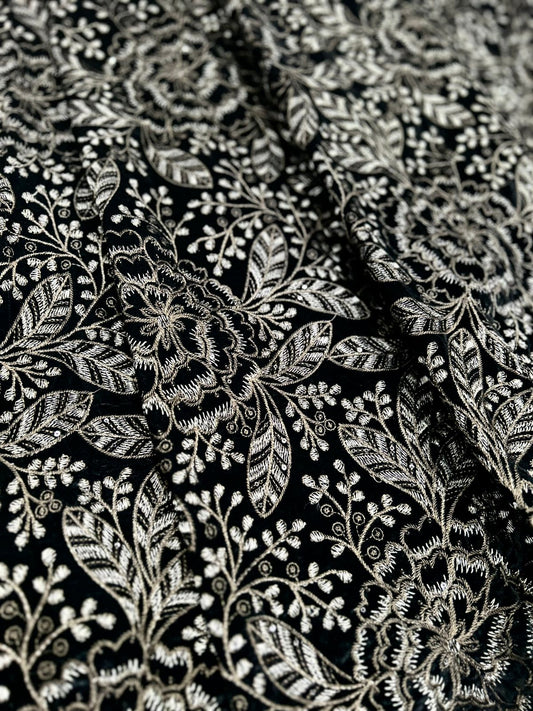 New style premium black velvet fabric with intricate gold and silver zari embroidery in a floral and leaf motif. Luxurious texture, high-quality micro eagle velvet, ideal for formal wear for men.