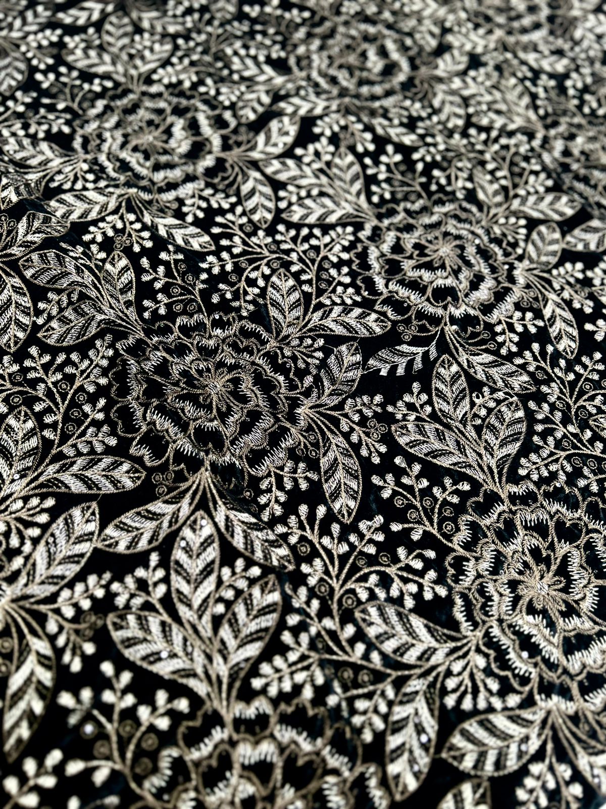 "Experience luxury with this stunning new style premium velvet fabric! It's a gorgeous black adorned with beautiful gold and silver embroidery featuring intricate flowers and delicate leaves. Perfect for creating something truly special!"