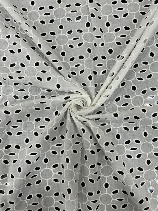 Close-up of beautiful white embroidered cotton textile for ethnic wear and fashionable Indo-Western dresses.